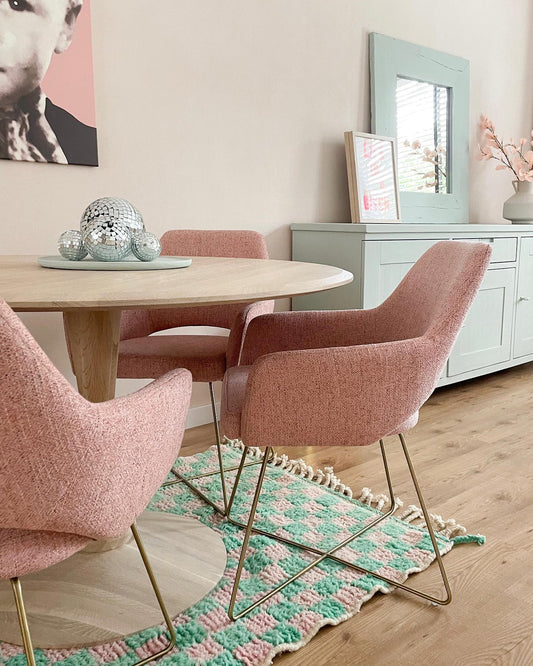 pink dining chairs with gold frames on a rug in a pastel room 2